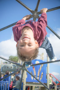 Low angle portrait of happy boy playing at playground