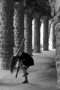 Woman dancing in corridor of old building