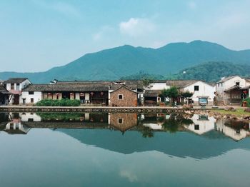 View of calm river with houses in background