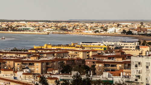 High angle view of townscape by sea against sky