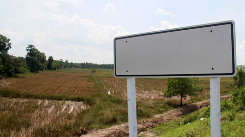 Empty road on field against sky