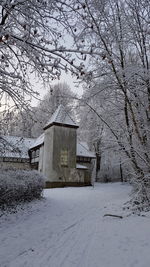 House on snow covered field by building