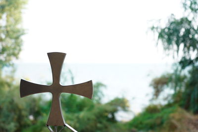 Close-up of cross against clear sky