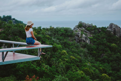 Woman standing by plants against sky