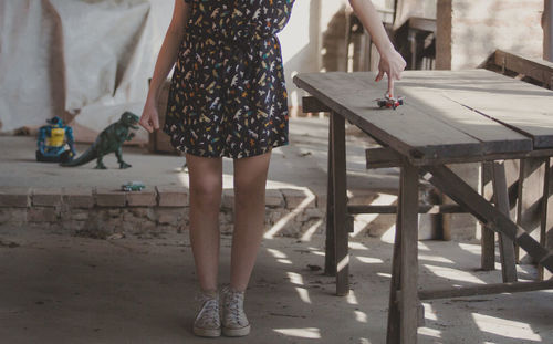 Low section of woman playing with model airplane on table