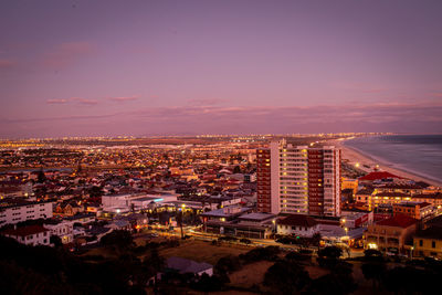 High angle view of illuminated cityscape against sky during sunset