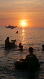 People sitting on boat at sunset