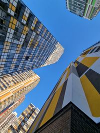 Low angle view of modern buildings against clear blue sky