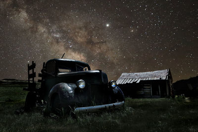 Abandoned truck on field against sky at night