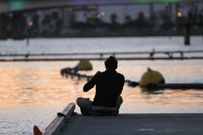 Rear view of man sitting against the sky