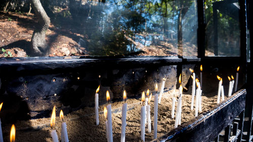 Close-up of candles burning outdoors