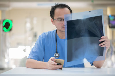 Midsection of man using mobile phone