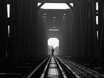 Rear view of man on railroad tracks