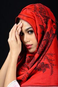 Portrait of woman with red face against black background