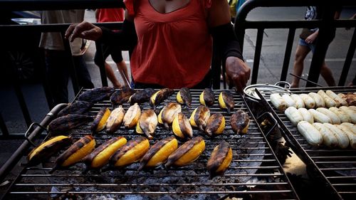 Close-up of man preparing food on barbecue grill