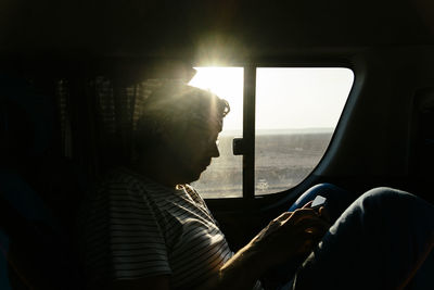 Mid adult man using phone in car