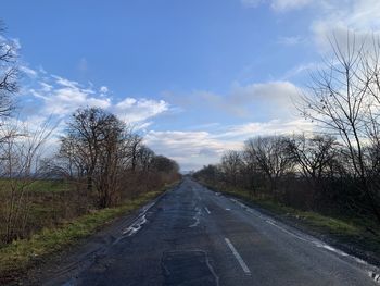 Road amidst trees against sky