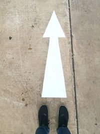 Low section of man standing on road