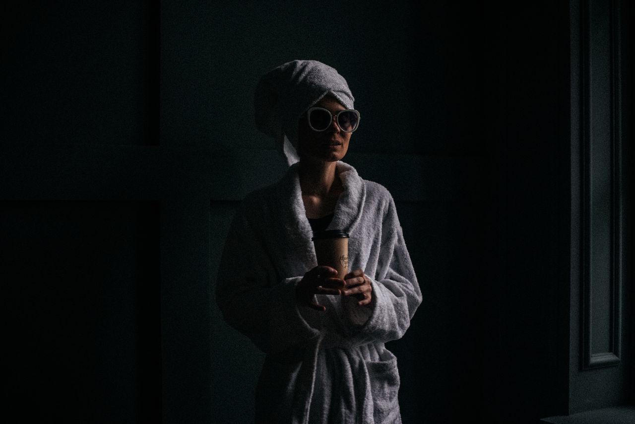 darkness, one person, black, adult, indoors, standing, dark, waist up, communication, men, copy space, technology, performance art, screenshot, stage, holding, looking, front view, clothing, young adult, lifestyles, wireless technology