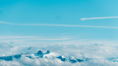 Scenic view of snowcapped mountains against blue sky