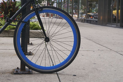 Close-up of bicycle wheel in city