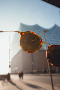 Close-up of sunglasses on glass against sky