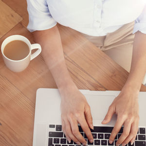 Midsection of man using laptop on table