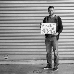 Portrait of man standing against wall