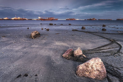 Scenic view of rocks on beach against sky