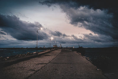 Empty road against cloudy sky