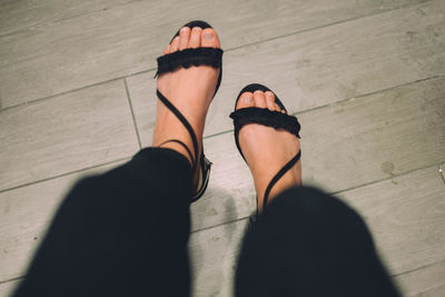 Low section of woman standing on hardwood floor