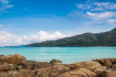 Scenic view of sea and mountains against sky