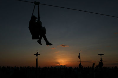 Low angle view of silhouette swing against sky