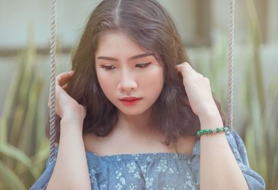 Close-up of beautiful woman sitting on swing