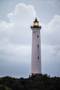 Lighthouse by sea against sky