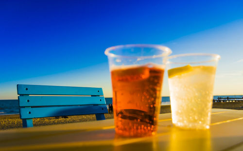 Close-up of drink on table against blue sky