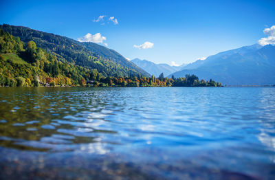 Scenic view of lake and mountains against blue sky