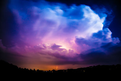 Scenic view of dramatic sky over silhouette landscape