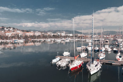 Sailboats moored at harbor