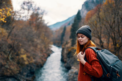 Woman standing by tree on mountain during winter