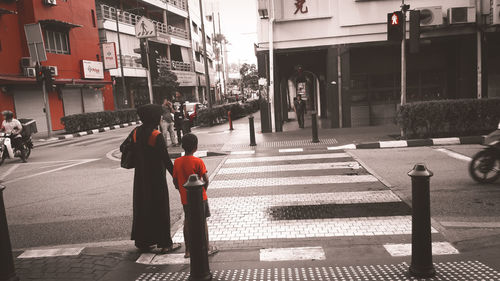 Rear view of people walking on road