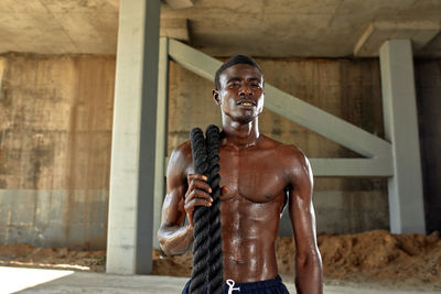 Portrait of young man standing against wall