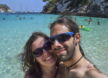 Close-up portrait of happy young couple at beach