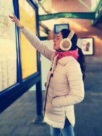 Full length of woman wearing hat standing in snow