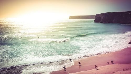 Scenic view of beach against clear sky during sunset