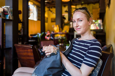 Portrait of smiling woman sitting in cafe