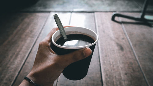 Close-up of hand holding coffee cup