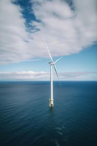 Drone aerial view of windmill in the ocean in a sunny day. ai generated