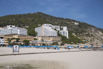 Scenic view of beach by buildings against sky