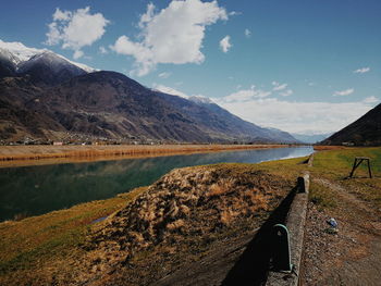 Scenic view of lake by mountains against sky